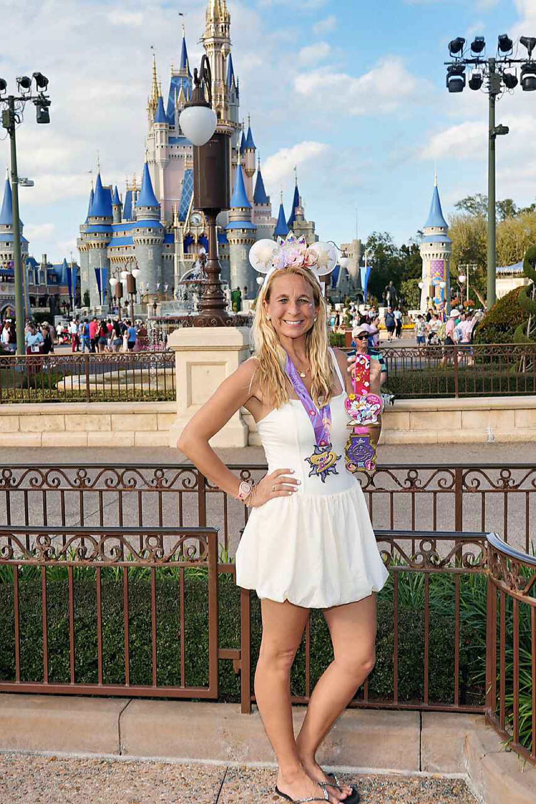 Fallon at Cinderella Castle wearing a runDisney medal.
