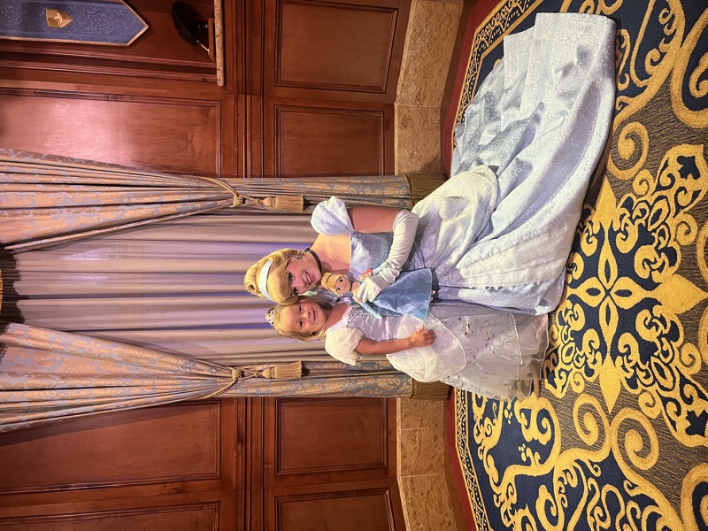 An open delivery box with three folded princess dresses inside tissue paper and a handwritten kid card on top.
